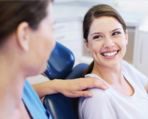 Dentist laughing with patient in treatment room