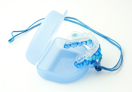 an open retainer box holding an upper and lower custom mouthguard