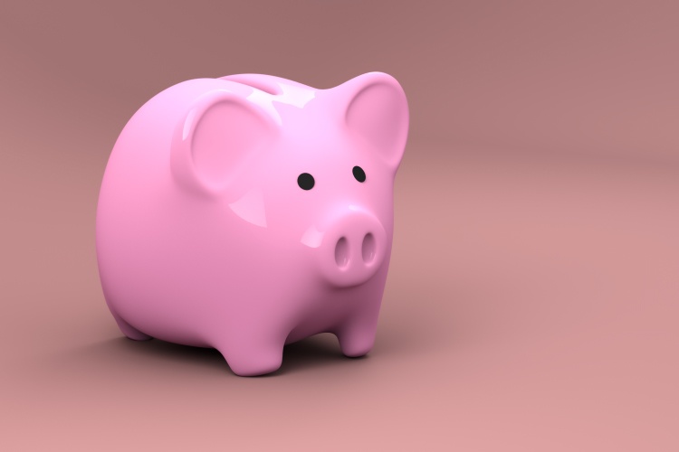 Pink piggy bank against a pink background used for saving money after receiving affordable dental care